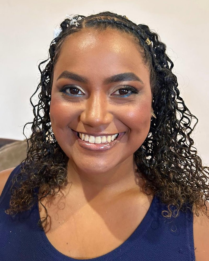 Cliente sorrindo com tranças e pele glow, maquiagem por Maria Eduarda Lima